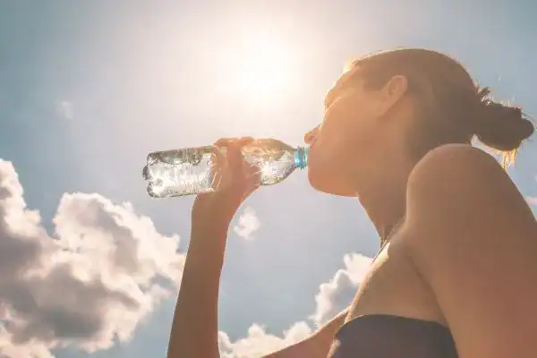 Hydration: The Secret Ingredient for a Toned Stomach and Enhanced Fitness 3 Image of woman drinking water to hydrate Royal Tunbridge Wells after run.
